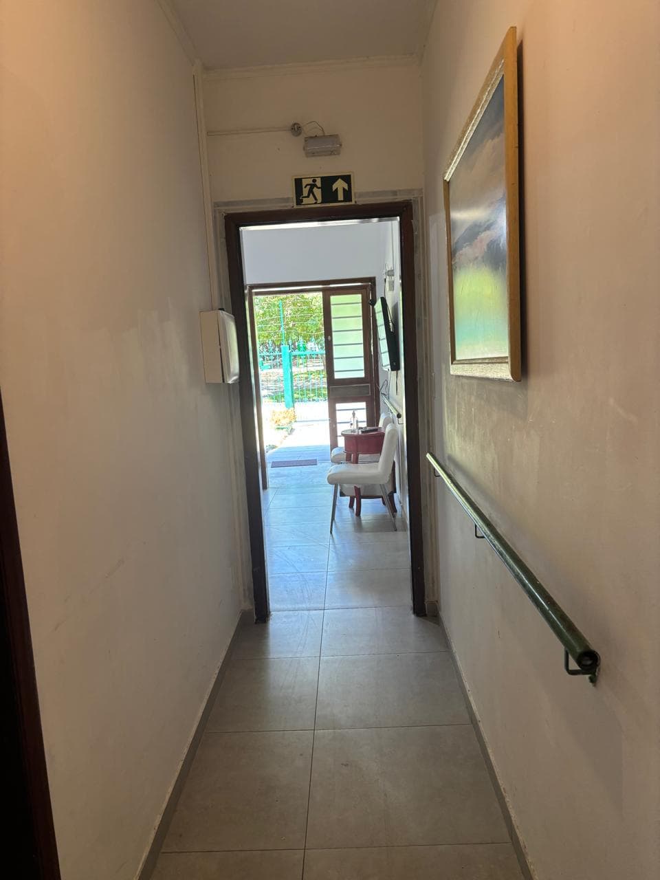 Corredor com corrimão de acessibilidade e sinalização de emergência