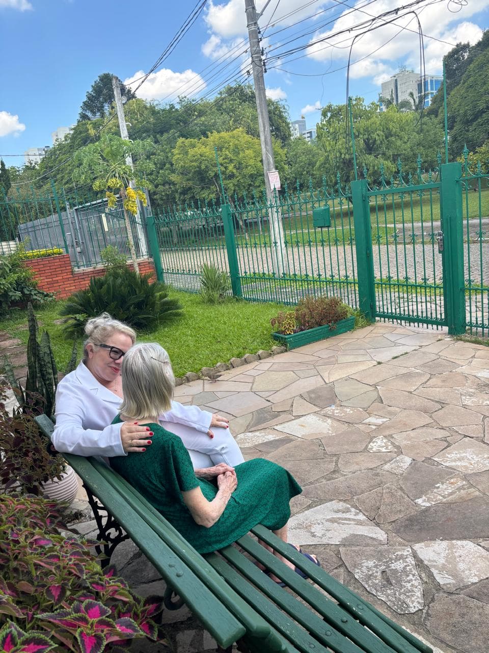 Jardim externo com área verde e bancos para descanso