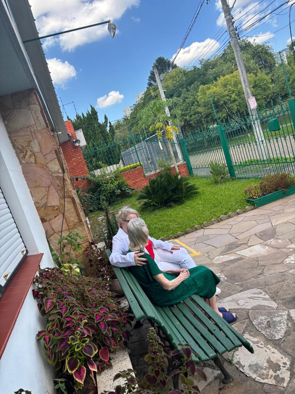 Área externa com banco e jardim